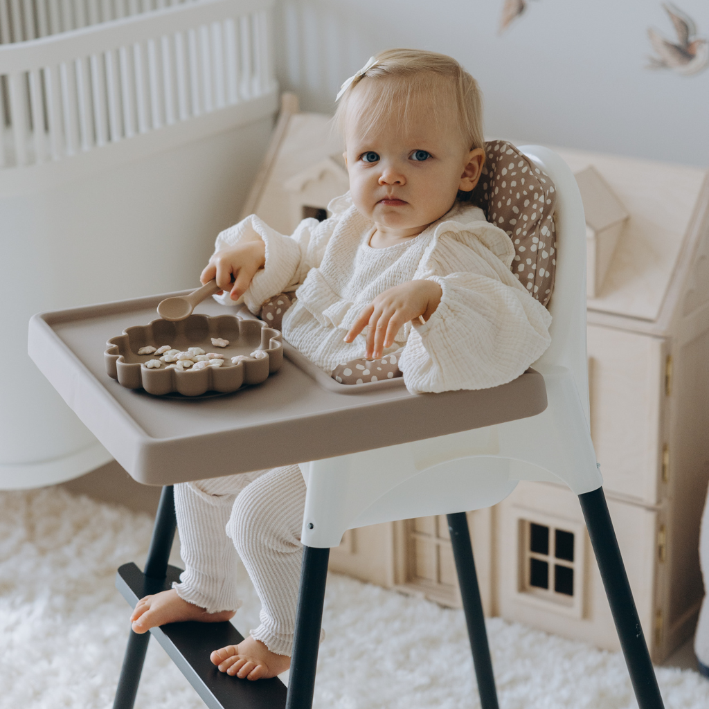 Baby girl sitting on stokke high chair