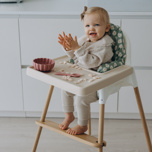 Baby eating in IKEA highchairs in wipe clean cushion cover, resting feet on wooden footrest by AZEbabydream
