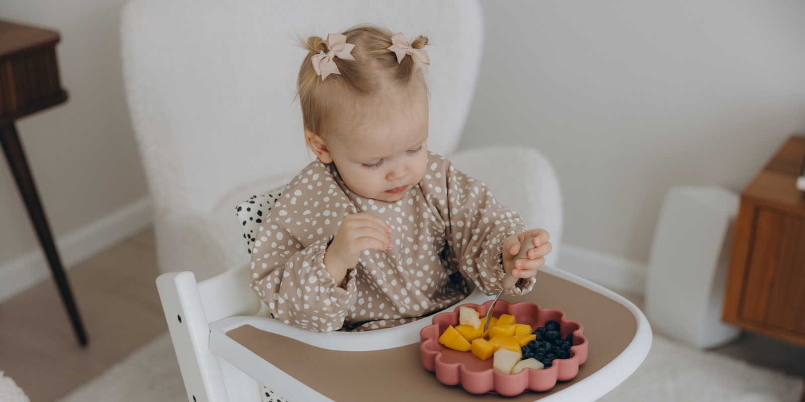 Baby seated in ikea highchairs and eating in wipe clean long sleeve weaning bib from sand suction plate  by azebABYDREAm