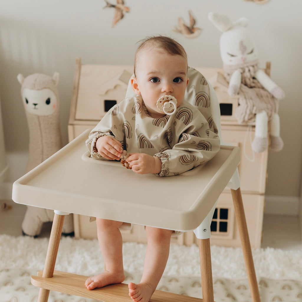 baby calmly seated with a pacifier